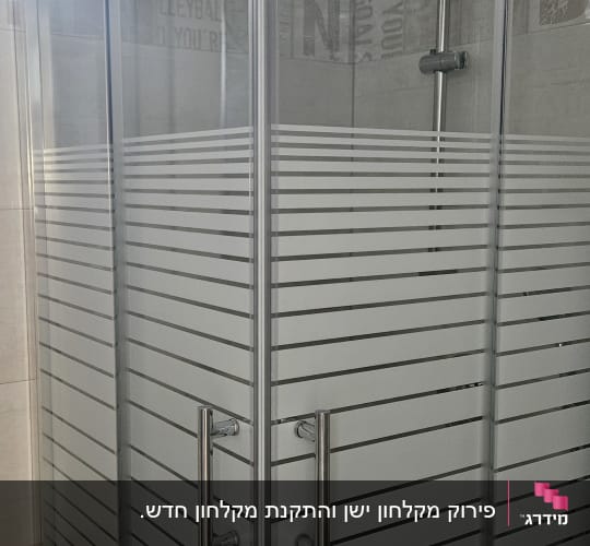 מקלחון פינתי עם דלתות הזזה מזכוכית ופסי טשטוש אופקיים